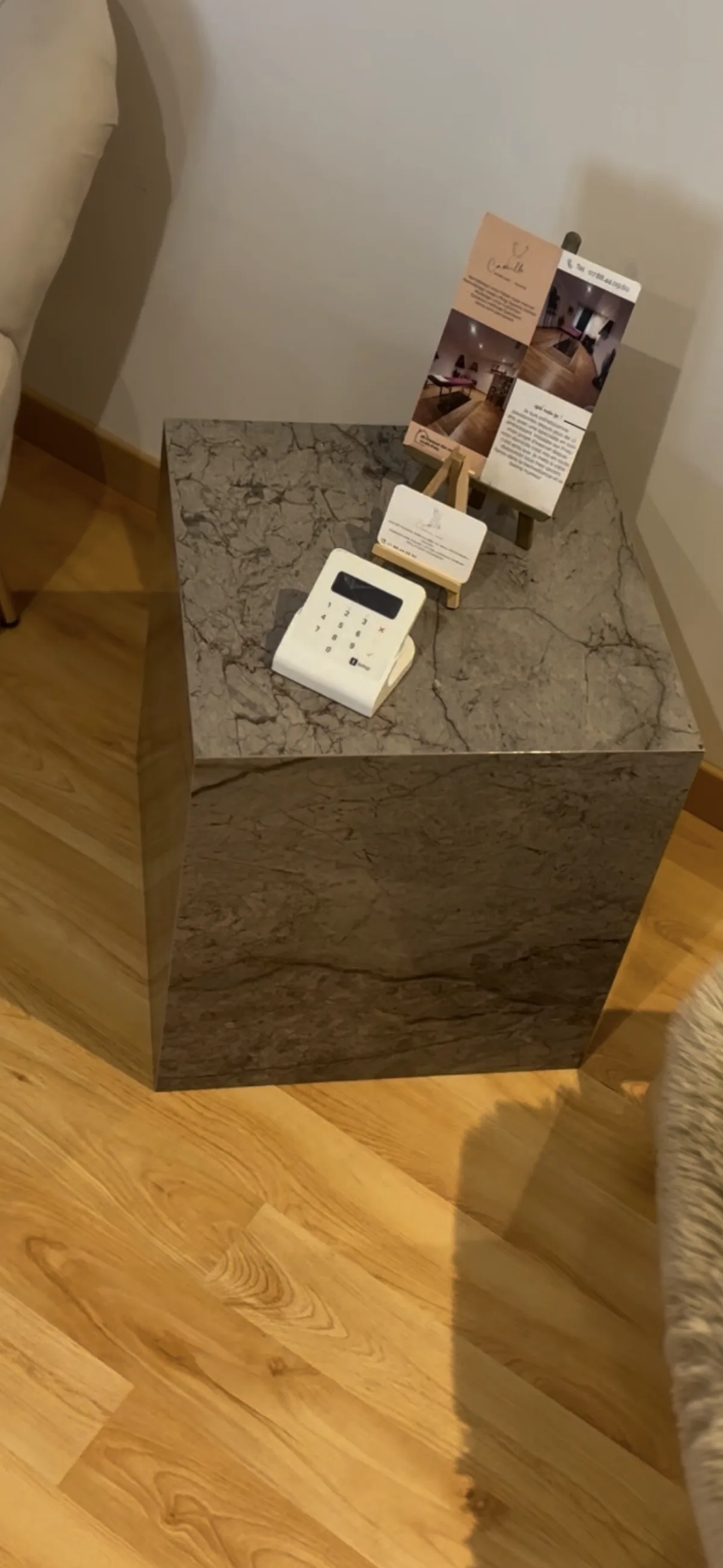 Table basse cubique habillée de carrelage effet marbre brun et rosé, façonnage sur chant.